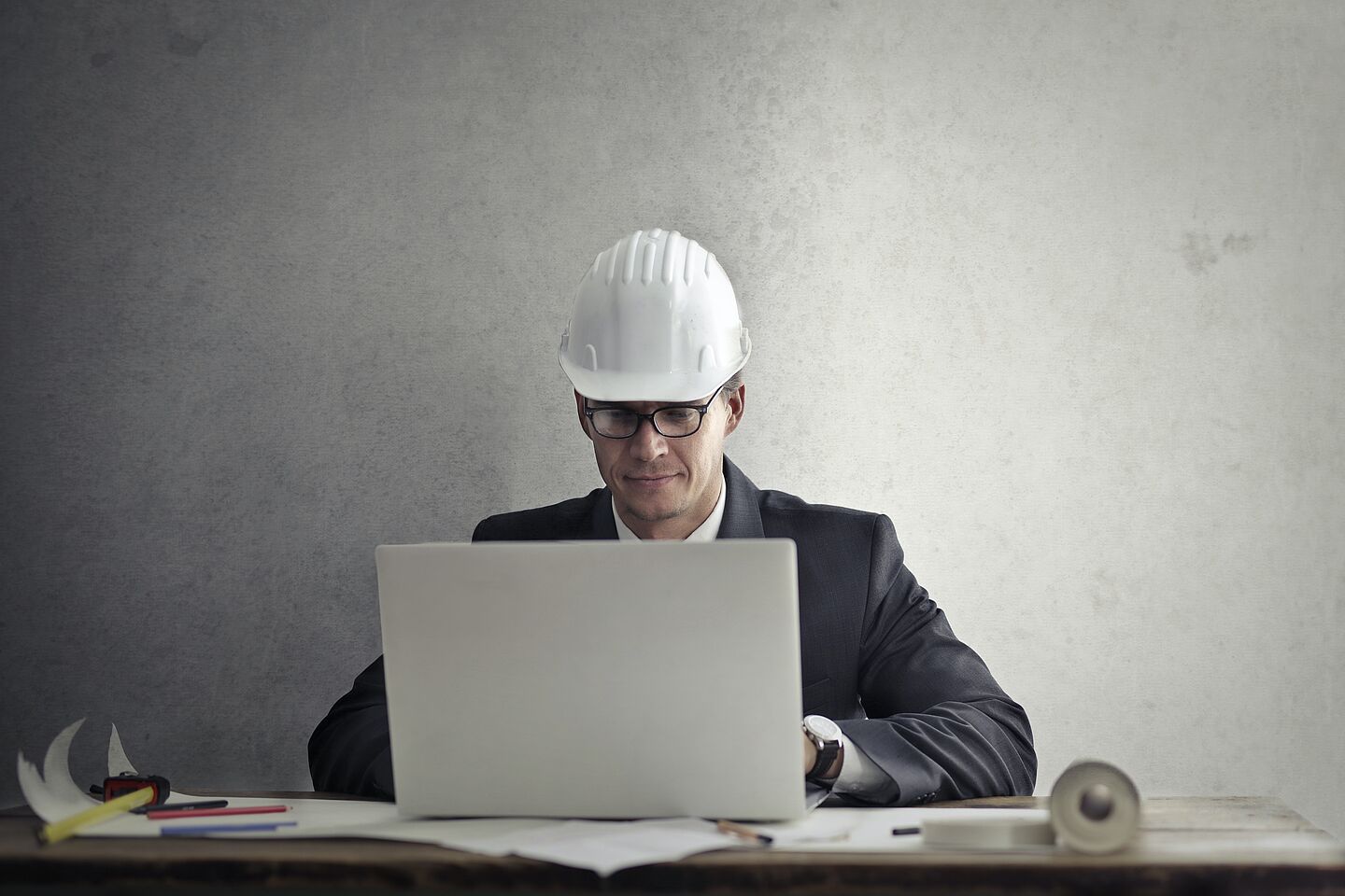 Geschäftsmann mit Helm am Laptop